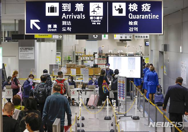 [오사카=AP/뉴시스] 일본에서 코로나19 오미크론 변이 감염자가 처음 발견된 11월30일 오사카 간사이 국제공항에 내린 승객들이 검사를 받기 위해 줄을 서서 대기하고 있다. 2021.12.01
