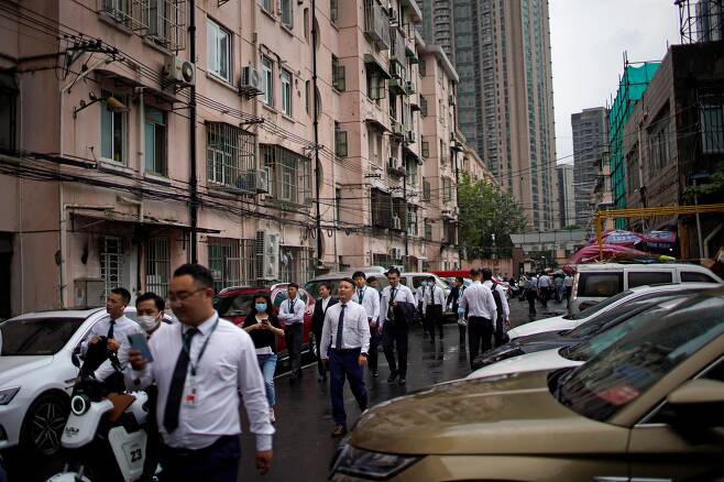 중국 상하이의 주거지역에서 지난 15일 부동산 중개인들이 무리를 지어 걸어가고 있다. /로이터 연합