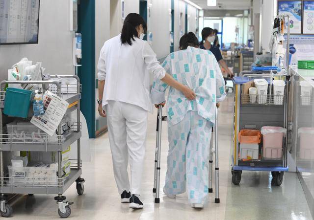 간호간병통합병동인 건보공단 일산병원 정형외과 병동에서 최은주 간호사가 재활치료를 마친 환자를 부축해 병실로 데려가고 있다. 일산=배우한 기자