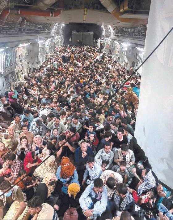 지난 9월 15일 아프가니스탄을 탈출하는 아프간인 640명이 미 공군 C-17 수송기에 발 디딜 틈 없이 앉아 있다. 공식 최대 탑승 인원은 134명이지만 아프간인들이 후방 적재문으로 몸을 밀어 넣어 탑승했다. [로이터=연합뉴스]