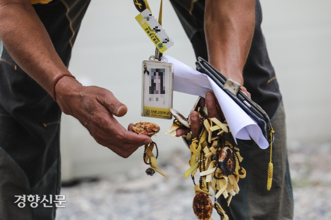 전남 진도군 팽목항 세월호 희생자 분향소 앞에서 한 아버지가 시간의 흐름으로 낡아버린 노란 리본들을 정리하고 있다. 이준헌 기자