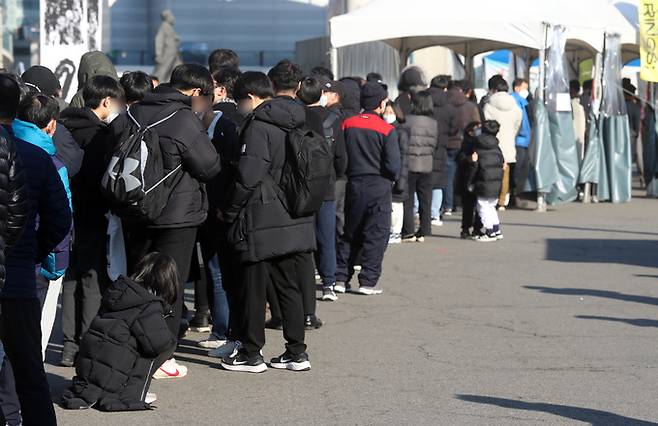 코로나19 신규 확진자 수가 사상 처음으로 7000명을 넘은 8일 서울역 임시선별검사소에서 학생들이 줄을 서고 있다. 뉴시스