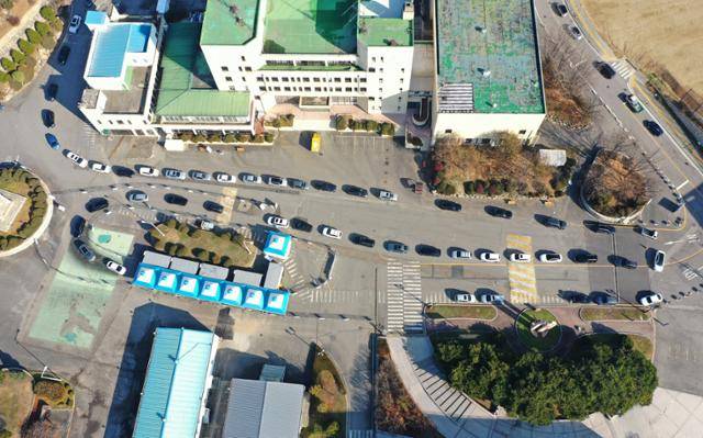 하루 신규 확진자가 7,000명을 넘어 선 8일 인천 미추홀구 인천대 제물포캠퍼스에 마련된 드라이브스루 임시선별진료소에서 차량들이 코로나19 검체 검사를 받기 위해 줄을 서 있다. 인천=홍인기 기자