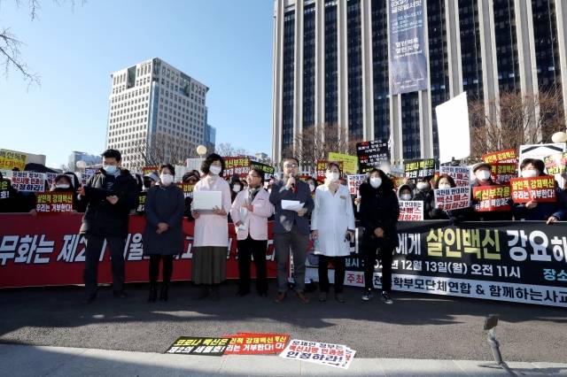 지난 13일 오전 서울 종로구 정부서울청사 앞에서 전국학부모단체연합 주최로 열린 '백신접종과 백신패스를 강요하는 정부를 규탄하는 기자회견'에 참석한 의사들이 마스크를 벗고 발언하고 있다. 뉴시스