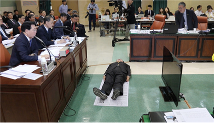 ▲신문지를 깔고 바닥에 드러누워 일반 수용자의 과밀 수용 실태를 보여주고 있는 노회찬 ⓒ노회찬재단