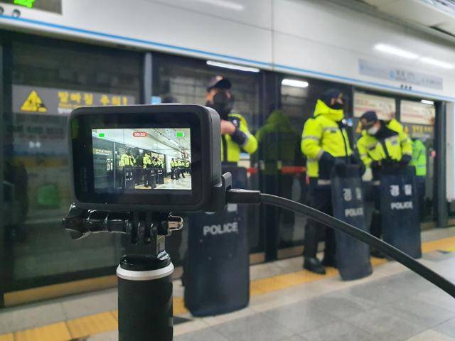 15일 서울 종로구 혜화역 승강장에서 경찰들이 전국장애인차별철폐연대 회원들의 승·하차 시위를 막으며 전철 출입구 앞마다 방패를 들고 대기하고 있다. 이규식씨가 휠체어 앞쪽에 설치한 카메라 화면에도 경찰들이 보인다. 전혼잎 기자