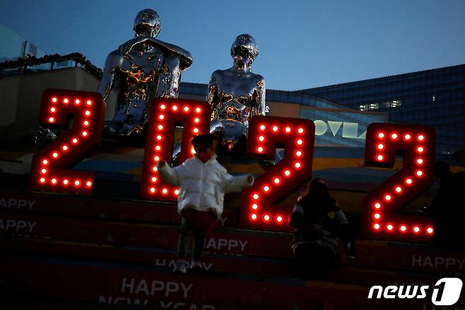 중국 베이징 한 쇼핑몰 앞에서 새해 전야인 2021년 12월 31일 마스크를 쓴 한 아이가 신년 조형물 앞에 서 있는 모습/ © 로이터=뉴스1 © News1 최서윤 기자