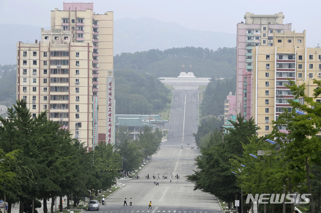 [개성=AP/뉴시스]김정은 북한 국무위원장이 개성에서 신종 코로나바이러스 감염증(코로나19)에 걸린 것으로 의심되는 탈북자가 월북하면서 개성시를 전면 봉쇄했다고 북한 관영매체가 26일 보도했다. 앞서 조선중앙통신은 "3년 전 탈북했던 한 주민이 코로나19에 걸린 채 지난 19일 북한으로 귀향하는 비상사건이 발생하였다"라고 전했다. 사진은 지난 23일 북한 개성에서 주민들이 길을 건너는 모습. 2020.07.26.