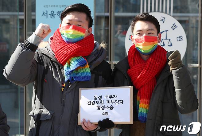 동성 부부 소성욱(왼쪽), 김용민 씨가 2021년 12월18일 서울행정법원 앞에서 동성 배우자 건강보험 피부양자 소송 기자회견을 한 뒤 구호를 외치고 있다. 2021.2.18/뉴스1 © News1 박정호 기자