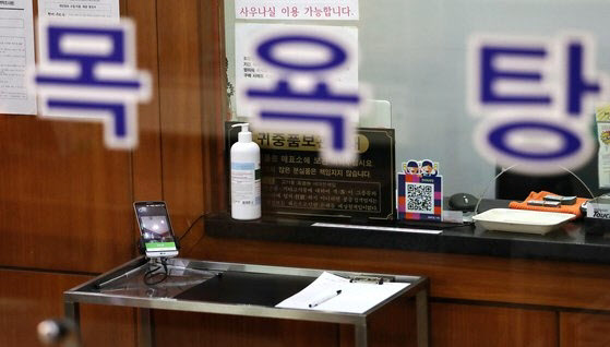 목욕장업 전자출입명부 사용이 의무화된 지난해 3월 16일 서울의 한 목욕탕에 전자출입명부와 수기로 작성하는 출입명부가 놓여 있다. (사진=뉴스1 )
