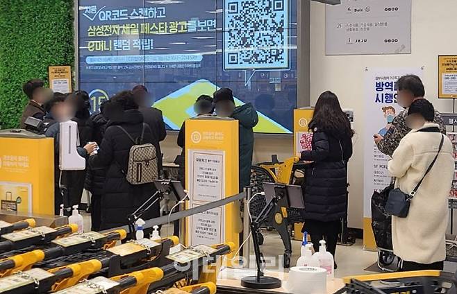 10일 오후 서울 성동구의 한 대형마트 출입구에서 시민들이 방역패스를 확인하기 위해 줄을 서고 있다. 직원이 앱 업데이트가 되지 않은 고객을 안내하면서 대기 줄이 길어지고 있는 모습이다.(사진=이용성 기자)