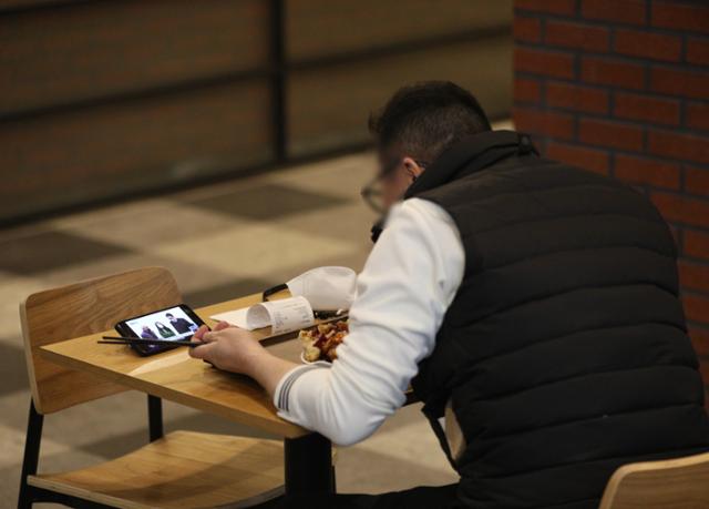2021년 12월 20일 서울의 한 식당가에서 시민이 '혼밥' 식사를 하고 있다. 사회적 거리두기 강화에 따라 방역패스 미소지자는 식당과 카페 등을 1인 단독으로만 이용할 수 있다. 뉴스1