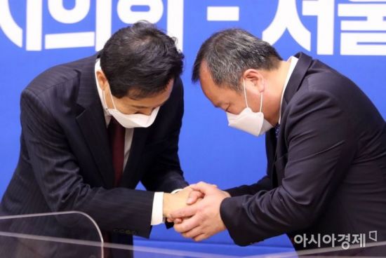 오세훈 서울시장(왼쪽)과 김인호 서울시의회 의장이 만나 안수를 나누며 인사하고 있다.