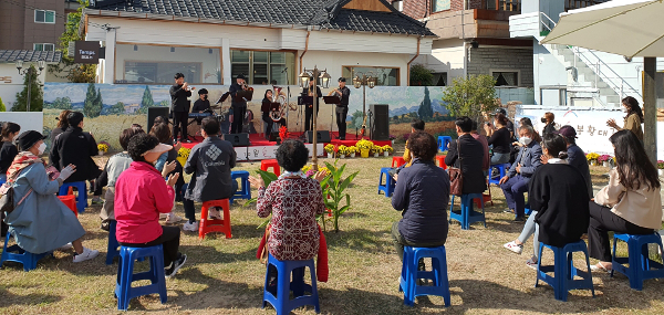 회현동 마을 버스킹 공연에 참석한 주민들이 박수치며 즐기고 있다.