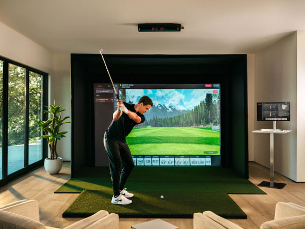 PGA 투어 장타자 캐머런 챔프가 거실에 설치된 큐이디 스크린골프에서 스윙연습을 하고 있다.  [사진 제공 = 큐이디]