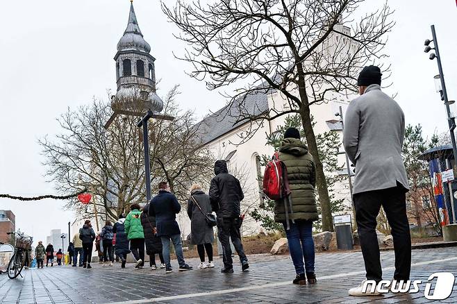 덴마크 올보르그 중심가에 위치한 부돌피 교회 코로나19 검진소에서 2021년 12월 23일 사람들이 검사를 받기 위해 대기하는 모습.  © AFP=뉴스1