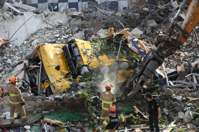 지난해 6월 광주 동구 학동에서 철거 작업 중이던 건물이 붕괴돼 시내버스 등이 매몰됐다. 사진은 사고 현장에서 119 구조대원들이 구조 작업을 펼치는 모습. 연합뉴스