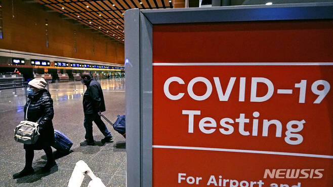 [보스턴=AP/뉴시스] 지난해 12월21일(현지시간) 미 매사추세츠주 보스턴의 로건 공항E 터미널에서 여행객들이 코로나19 검사소를 지나 이동하고 있다.  2021.12.22.