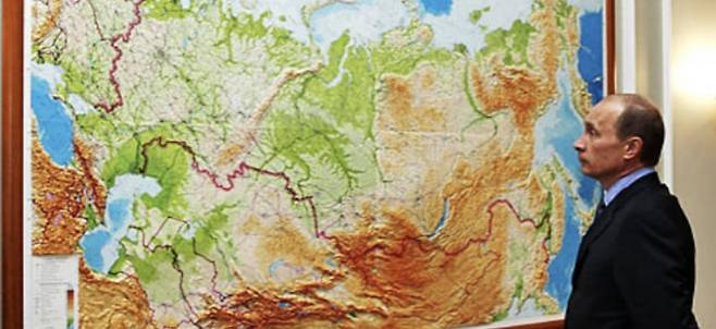블라디미르 푸틴 러시아 대통령이 동서로 펼쳐진 러시아 지도를 보고 있다./러시아 공보처