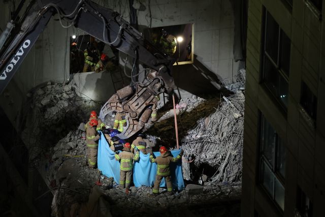 소방 대원들이 14일 광주 서구 화정동 아이파크 붕괴 현장 지하 1층에서 발견된 실종자 1명을 구조하고 있다. 하지만 이 실종자는 결국 숨진 상태로 수습됐다. 연합뉴스