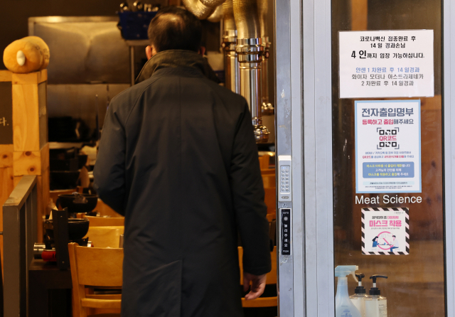 14일 오후 저녁 장사를 앞둔 서울 종로구의 한 식당 입구에 방역패스(백신접종증명·음성확인제) 관련 안내문이 부착돼 있다. /연합뉴스