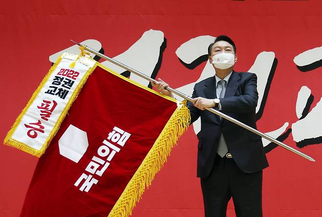 국민의힘 윤석열 대선 후보가 15일 오후 울산 동구 전하체육센터에서 열린 울산시 선거대책위원회 필승결의대회에서 필승기를 흔들고 있다. /연합뉴스
