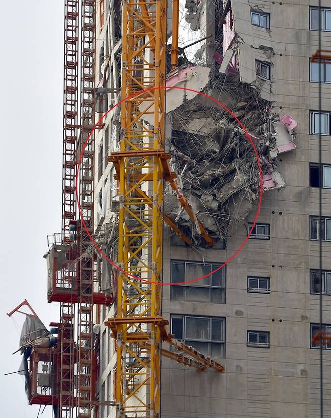 [광주=뉴시스] 광주 서구 화정동 현대아이파크 건설 현장, 공사 중에 외벽이 무너져 내려 내부 철골구조물 등이 드러나 있다. 빨간 원 안이 건물과 타워크레인을 잇는 구조물 '브레싱'(BRACING 플로링·월 타이). 붕괴 직전 총 8개의 브레싱 중 위에서 2번째 브레싱이 먼저 파손된 것으로 추정되고 있다. (사진=뉴시스DB)  2022.01.12. photo@newsis.com