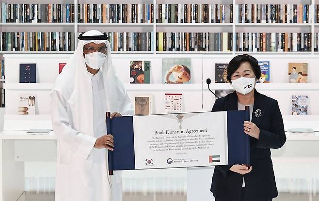 서혜란 국립중앙도서관장(오른쪽)이 16일 오전(현지시각) 김정숙 여사가 참석한 가운데 아랍에미리트 두바이의 모하메드 빈 라시드 도서관에서 열린 ‘한-UAE 지식문화 교류식’에서 모하메드 알무르 도서관장에게 기증 증서를 전달하고 있다. 두바이/윤운식 선임기자