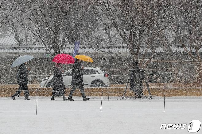 서울을 비롯한 수도권에 대설주의보가 발령된 19일 서울광장에서 우산을 쓴 시민들이 걸어가고 있다. 2022.1.19/뉴스1 © News1 안은나 기자