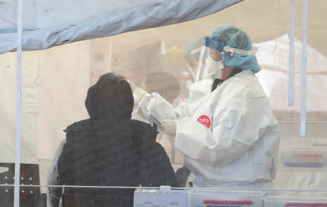 시민들이 지난 13일 부산 사상구보건소 선별진료소에서 신종 코로나바이러스 감염증(코로나19) 검사를 받고 있다. /연합뉴스