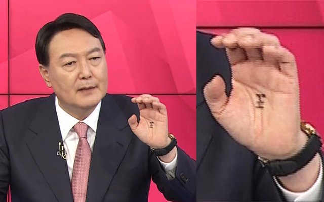 지난해 10월 TV 토론회 당시 윤석열 국민의힘 대선후보의 손바닥 한가운데에 '왕(王)' 자를 그린 장면이 포착되며 무속 논란이 일었다. 이번 주 부인 김건희씨 녹취록 속 '도사' 발언, 무속인 건진법사의 선대위 활동 등이 추가로 알려지며 더불어민주당은 '무당선대본' 공세 수위를 높이고 있다. MBN 유튜브 캡처