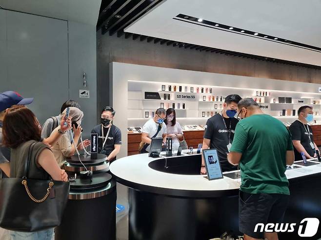 싱가포르 상업지구 비보 시티에 위치한 '삼성 익스프리언스 스토어'에서 관람객들이 3세대 폴더블폰 '갤럭시 Z 폴드3'와 '갤럭시 Z 플립3' 등 제품을 체험하고 있다./사진=뉴스1(삼성전자 제공)