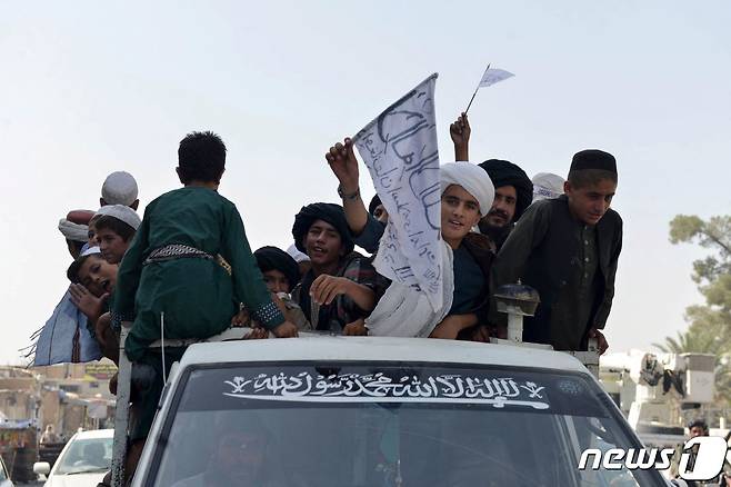 31일(현지시간) 미군이 철수를 완료한 아프가니스탄의 칸다하르에서 탈레반을 지지하는 청년들이 차량을 타고 깃발을 흔들고 있다. © AFP=뉴스1 © News1 우동명 기자