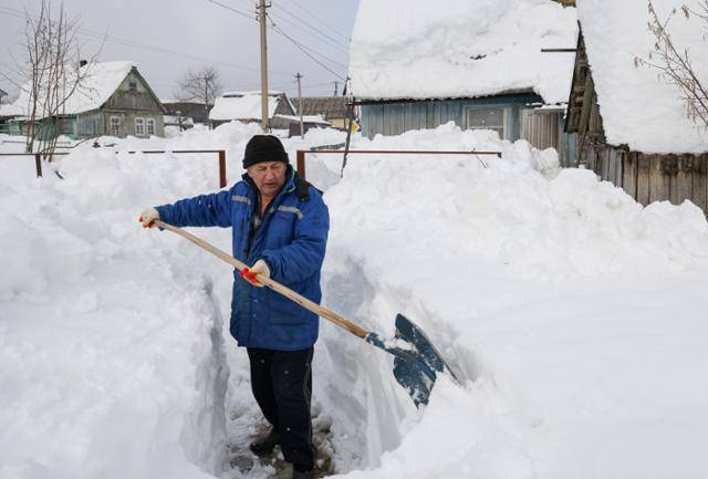 눈폭풍이 강타한 러시아 남서부 크라스노다르 준주 고르니 마을에서 25일 한 주민이 눈을 치우며 길을 만들고 있다. 고르니=타스 연합뉴스