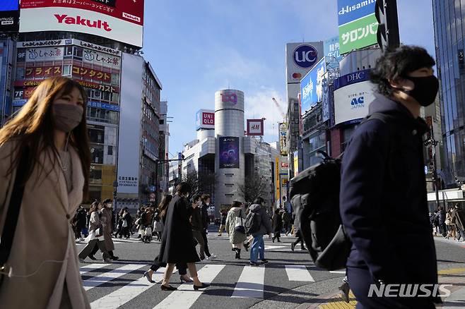 [도쿄(일본)=AP/뉴시스]지난 21일 일본 도쿄에서 코로나19 감염 예방을 위해 마스크를 착용한 시민들이 횡단보도를 건너고 있다. 2022.01.22.