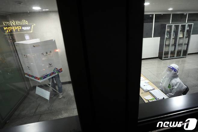 4·7 재보궐 선거일인 7일 저녁 서울 종로구의 한 투표소에 별도로 마련된 코로나19 자가격리자 임시 기표소에서 자가격리자들이 투표를 하고 있다. 2021.4.7/뉴스1 © News1 이광호 기자