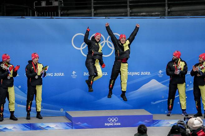 지난 15일 중국 베이징 옌칭 슬라이딩센터에서 열린 2022 베이징 동계올림픽 봅슬레이 남자 2인승에서 금, 은, 동메달을 모두 휩쓴 독일 선수들이 시상대에 올라 기뻐하고 있다. 베이징 | AP연합뉴스