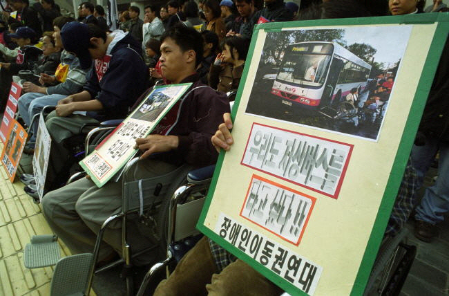 2001년 서울 세종문화회관 앞에서 열린 장애인 이동권 집회에서 참가자들이 저상버스 확대 도입을 촉구하고 있다. 그 후 20년이 지났지만 전국 시내버스의 저상버스 도입률은 30%에도 미치지 못한다. 경향신문 자료사진