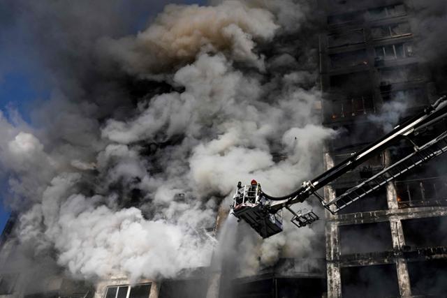15일 우크라이나 수도 키이우에서 크레인을 탄 소방관이 러시아군의 포격으로 화재가 발생한 아파트에서 진화 작업을 하고있다. 키이우=AFP 연합뉴스