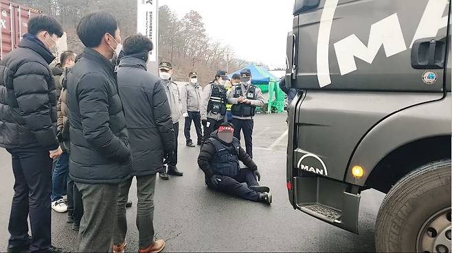 지난 1월 26일 한국타이어 금산공장에 진입하려는 화물 트럭 앞에 주저앉아 진입을 막고 있는 화물연대 노조원의 모습./독자 제공