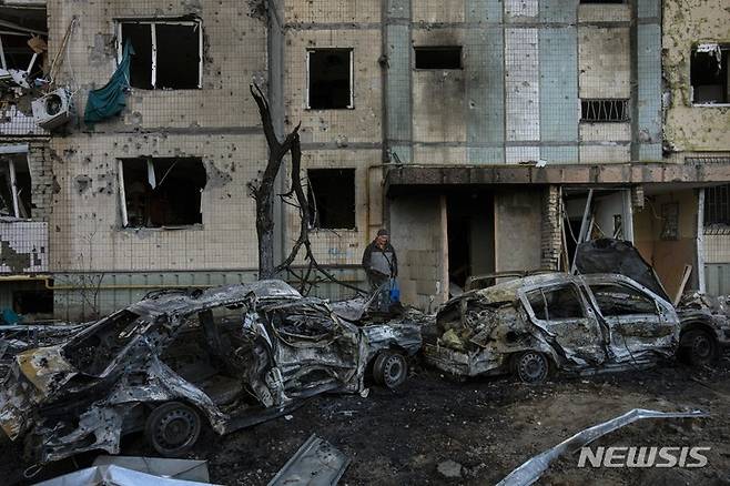 [키이우=AP/뉴시스] 20일(현지시간) 우크라이나 키이우의 아파트 건물과 자동차들이 러시아군의 포격으로 파괴돼 있다. 2022.03.21.