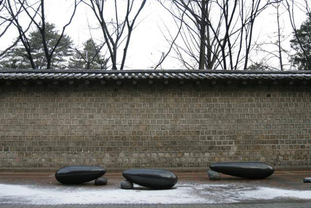 덕수궁 돌담길에 놓여 있는 최병훈 작가의 의자. 길다란 돌이 움직이지 않도록 작은 돌을 괴어 놓은 듯한 모습이다. 최병훈 작가 제공
