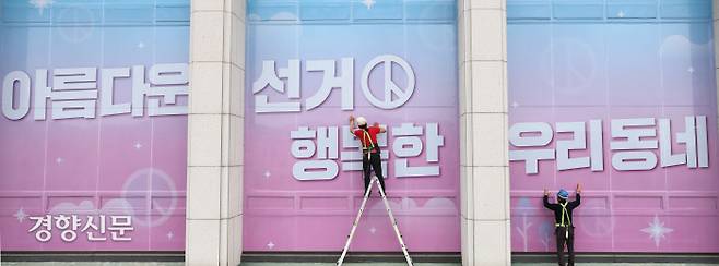 제7회 전국동시지방선거를 앞둔 2018년 5월 경기도 과천시 중앙선거관리위원회 건물 전면 외벽에 작업자가 지방선거 슬로건 ‘아름다운 선거, 행복한 우리동네’ 래핑 작업을 하고 있다. 경향신문 자료사진.