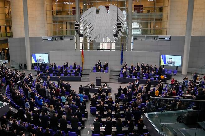 지난달 17일(현지 시각) 독일 수도 베를린의 의사당에서 볼로디미르 젤렌스키 우크라이나 대통령이 화상을 통해 연설을 마치자 하원 의원들이 기립 박수를 보내고 있다. /AP 연합뉴스