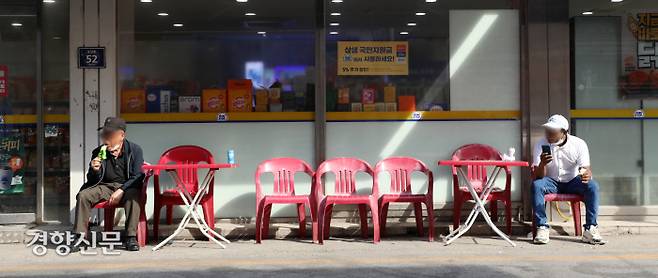 지난 10일 충북 음성군 대소면의 한 편의점 앞에서 내국인(왼쪽)과 이주민이 거리를 두고 앉아 있다. 권도현 기자