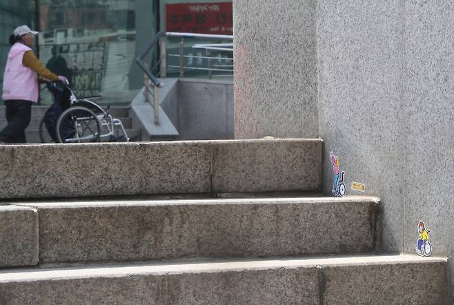 ‘장애물 없는 생활환경’ 인증 확대를 알리는 캠페인이 19일 오후 서울역 앞 계단에서 열려 비에프 스티커가 계단에 붙어 있다. 김태형 기자