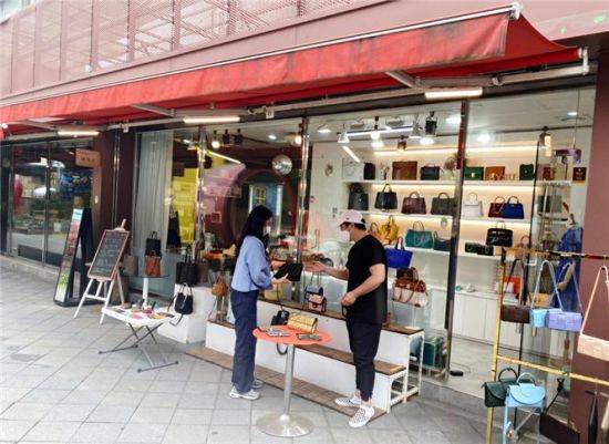 공동판매장에서 판매되는 물품을 구매하는 방문자의 모습. 저렴하면서 질 좋은 수제화 등 물건을 만나볼 수 있다.