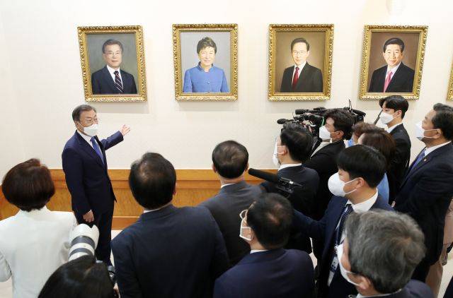 문재인 대통령이 3일 청와대 본관 세종실에서 열린 마지막 국무회의에 앞서 열린 사전환담에서 국무위원들과 역대 대통령 초상화와 함께 걸린 문 대통령의 초상화를 보며 대화하고 있다. 연합뉴스