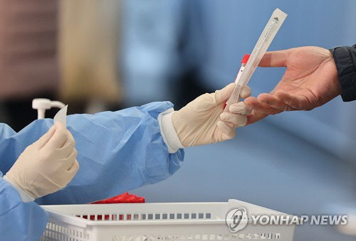 의료진이 코로나19 검체 진단 키트를 전달하고 있다. <연합뉴스>