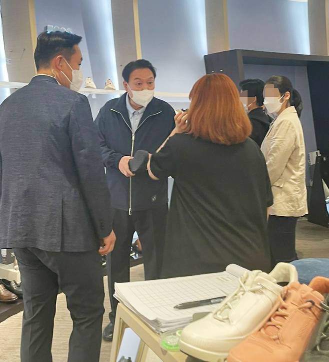 윤석열 대통령이 취임 후 첫 주말인 14일 서울 종로구 광장시장을 방문한 뒤 자택 인근 백화점을 찾아 구두를 구매하고 있다. /연합뉴스